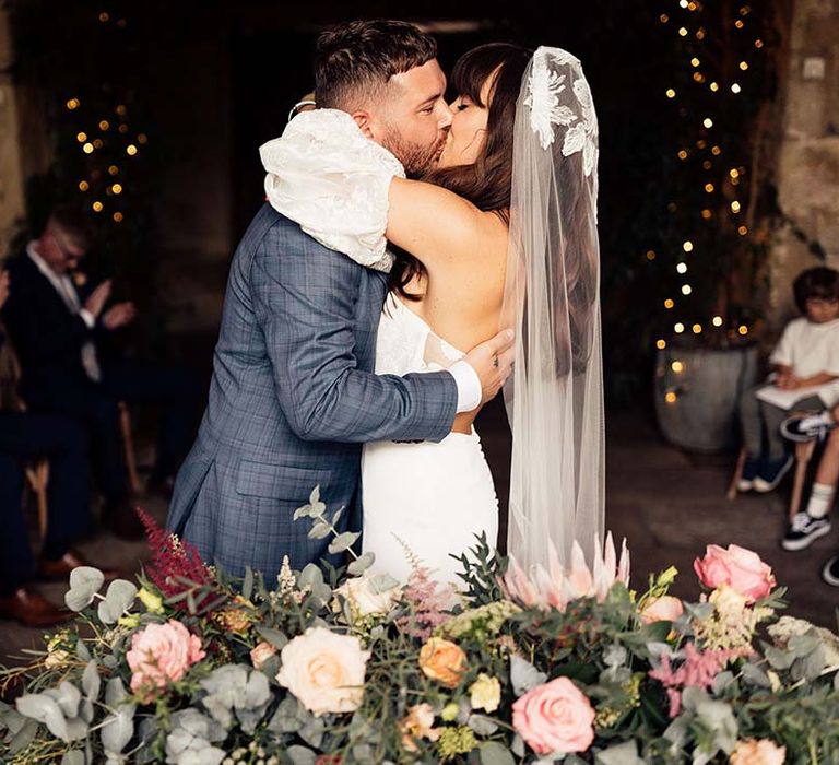 Bride & groom kiss on their wedding day during ceremony