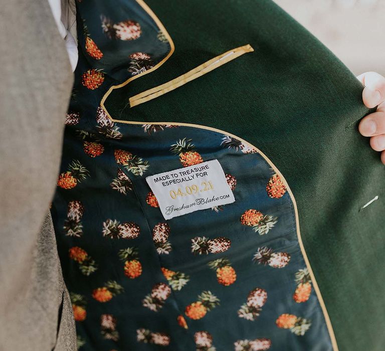 Groom wears green jacket complete with lining with pineapple fabric