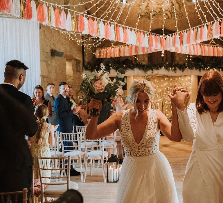 Brides celebrate as they walk down the aisle