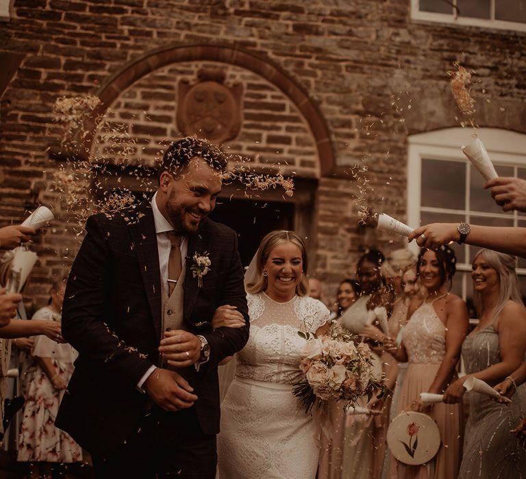 Confetti moment at Dewsall court with bride in a lace cap sleeve wedding dress