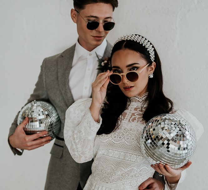 Bride & groom wear sunglasses whilst holding disco balls