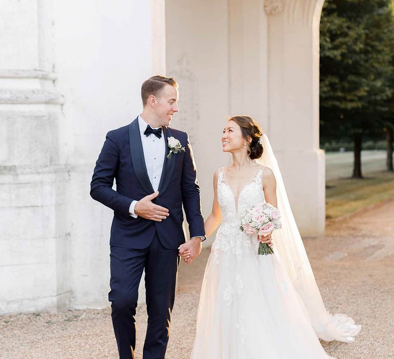 Bride & groom walk together through the grounds of Danesfield House after ceremony