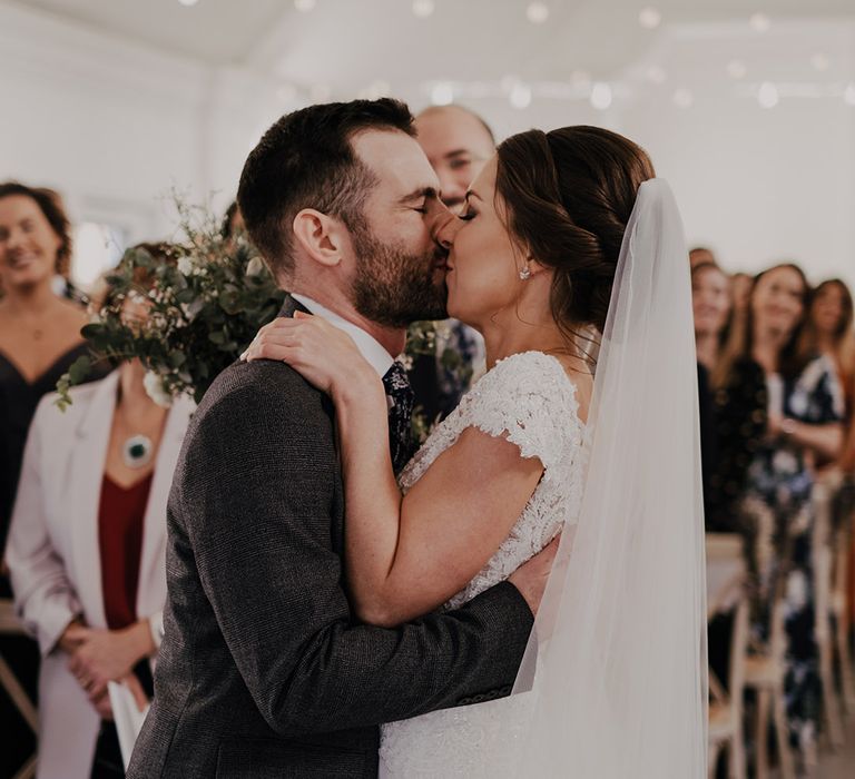 Bride & groom kiss on their wedding during ceremony