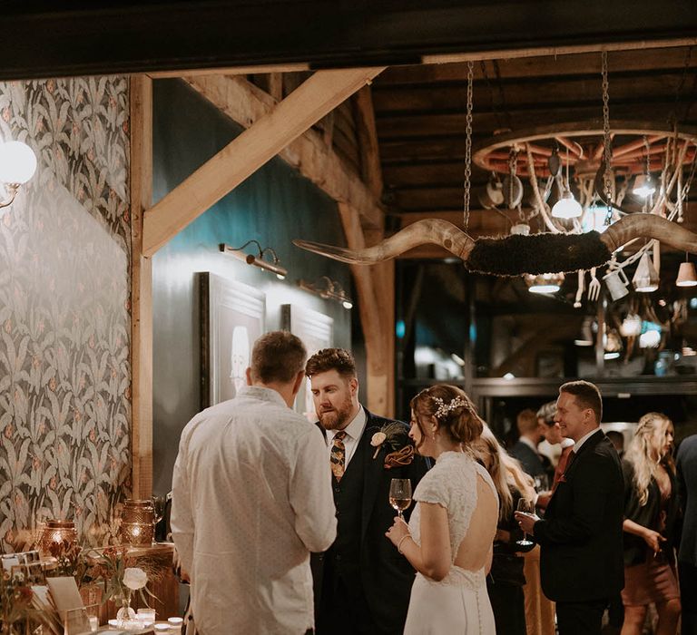 Bride in Rosa Clara open back dress mingles with wedding guests at The Barns at Redcoats 