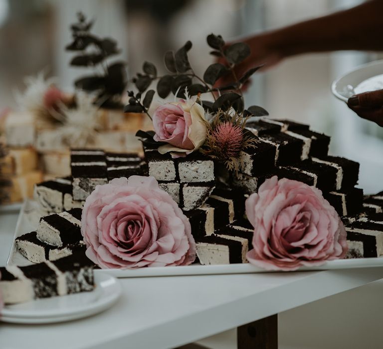 Chocolate wedding cake cut into slices complete with pink roses 