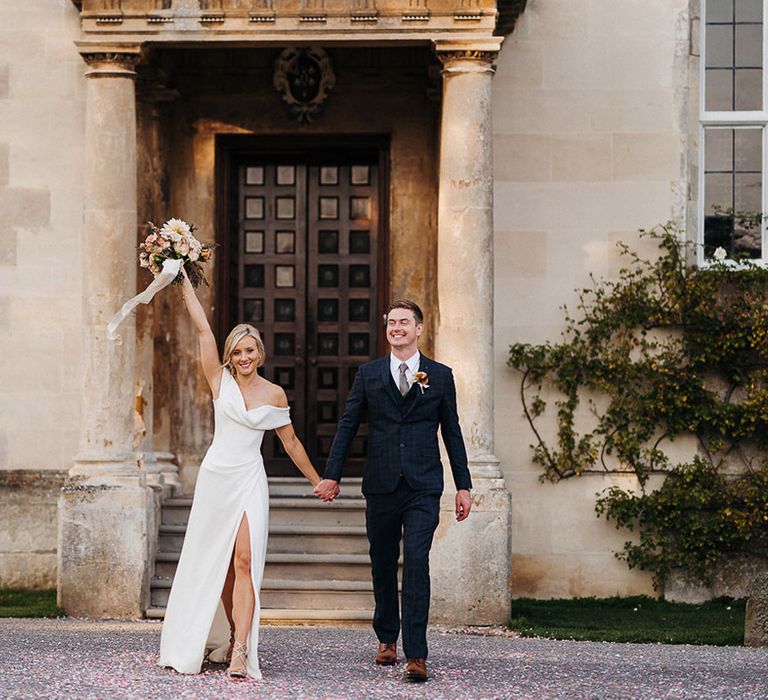 Bride and groom celebrate their marriage in front of wedding venue