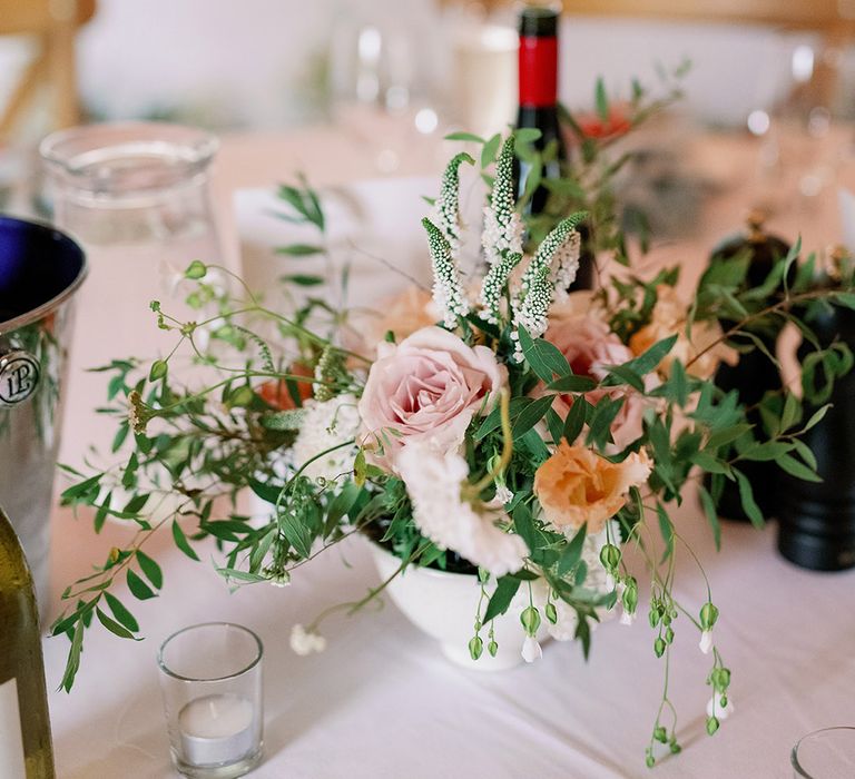 Pink, orange and green flower arrangement for the table setting 