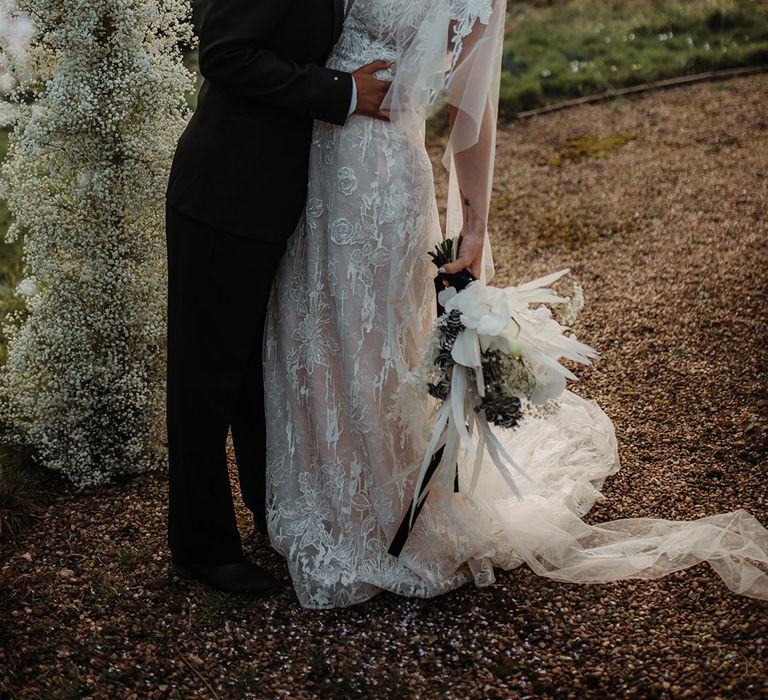 LGBTQI+ couple kissing at their Hodsock Priory winter wedding in black-tie suit and lace wedding dress