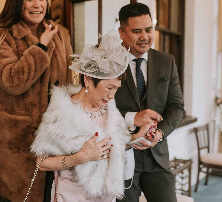 Wedding guest in fur shawl with cream, detailed hat 