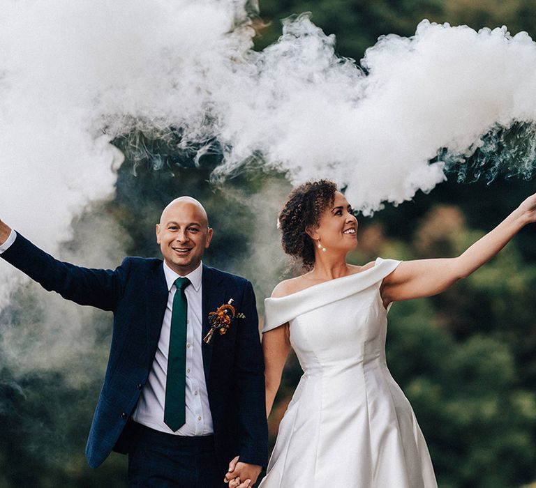 Bride and groom pose with white smoke bombs for pictures 