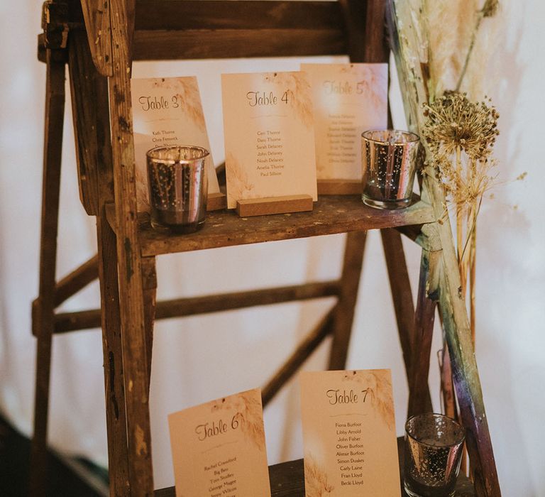 Seating chart cards on wooden ladder decor