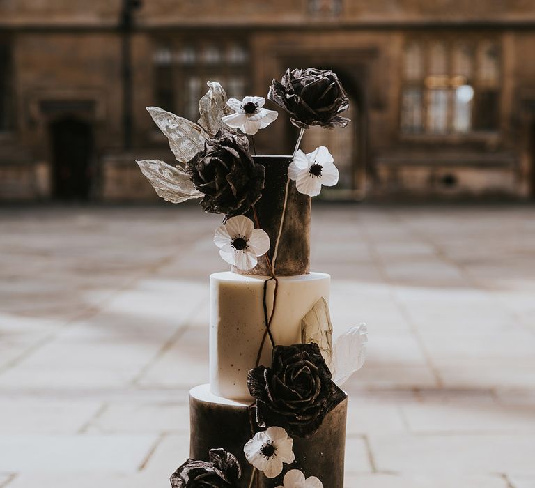 Three tier black and white wedding cake with decorative black and white flowers 