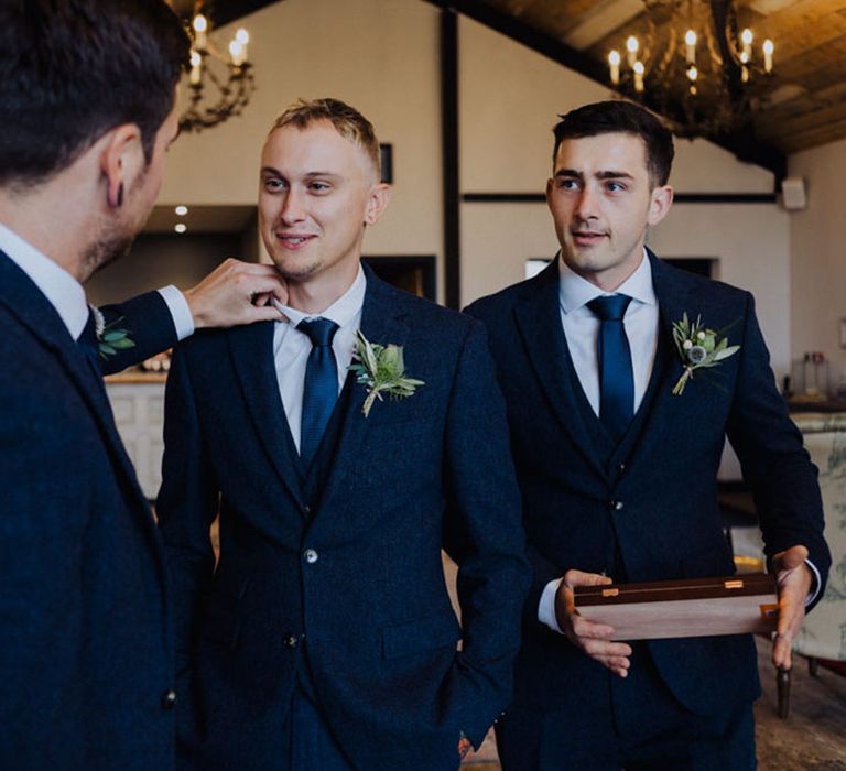 Groom with groomsmen all in matching blue suits and ties 