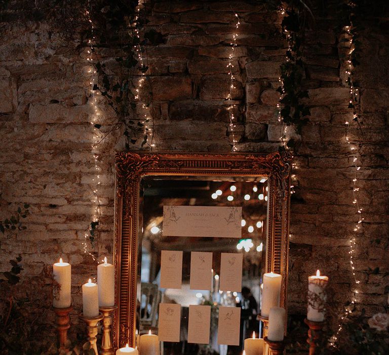 Gold vintage mirror table plan with pillar candles for a winter wedding