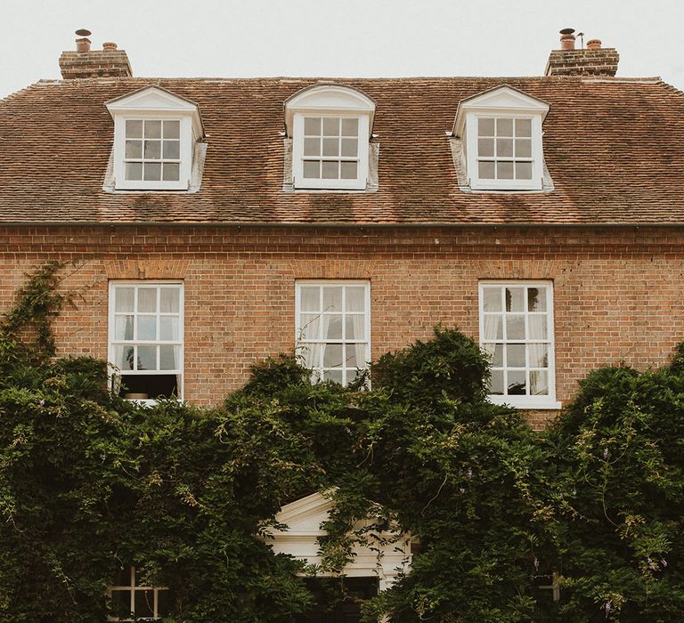 Bride and groom share an intimate embrace in front of Sprivers Mansion country house wedding venue