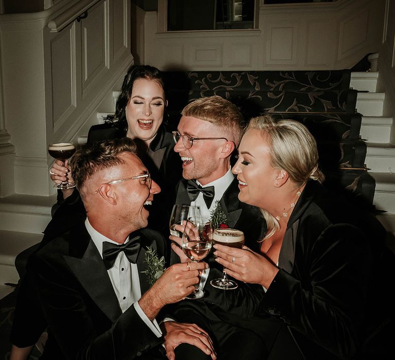 I Do Crew sitting on the stairs of the hotel venue during wedding cocktail hour with espresso martinis in hand