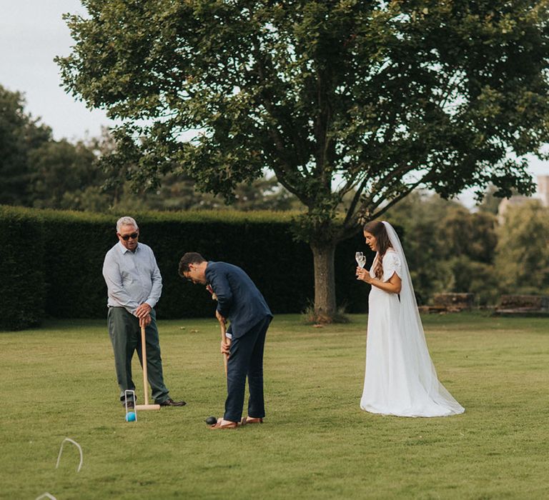 Bride and groom play croquet for wedding 