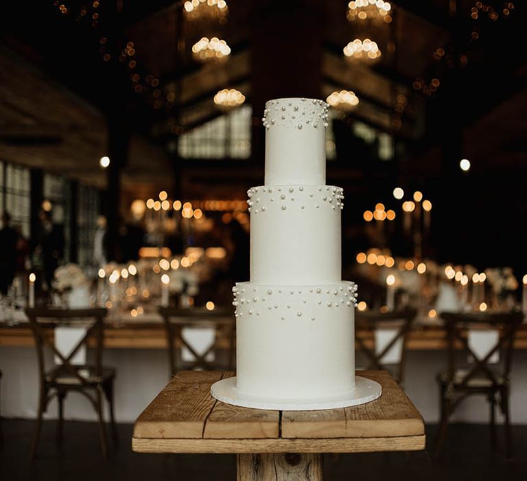 Simple and classic three tier white iced wedding cake with pearls 