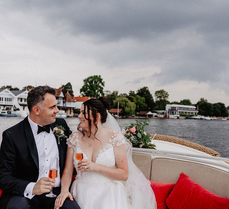 The bride and groom share some wine on their boat ride around Henley on Thames 