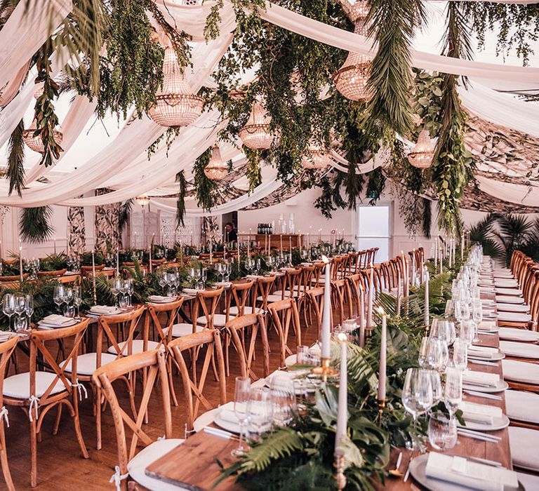 Iscoyd Park wedding marquee with gold chandelier lighting and foliage for greenery wedding theme and neutral candles 