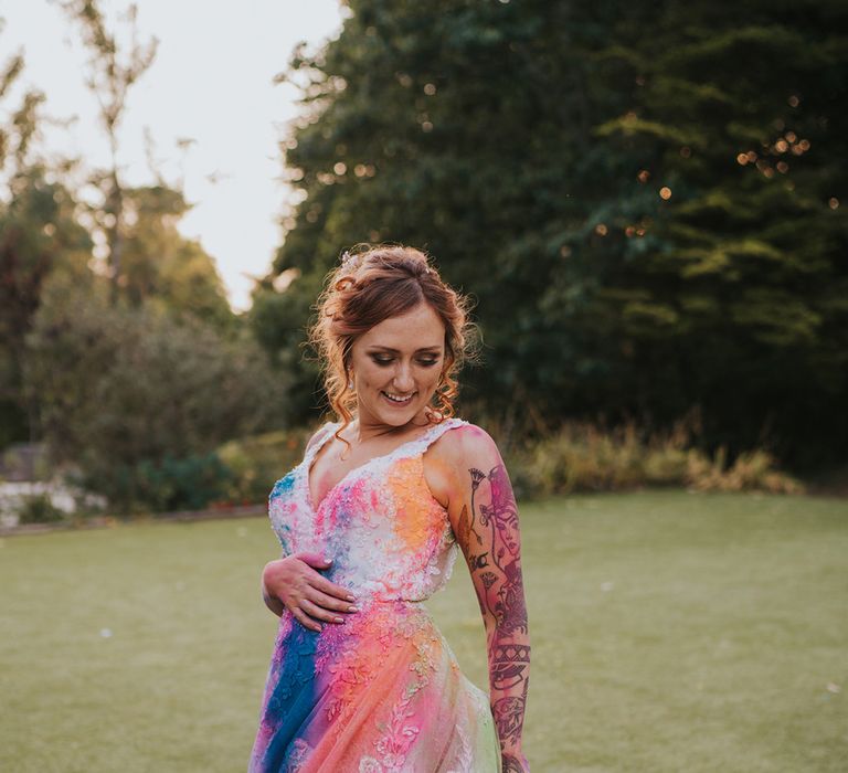 bride in a lace wedding dress withmcolouful Holi powder thrown over it for a trash the dress moment 