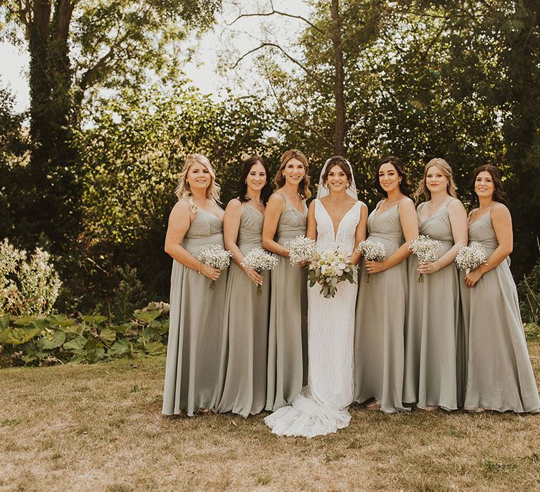 Bridal party in matching bridesmaid dresses in a sage green shade