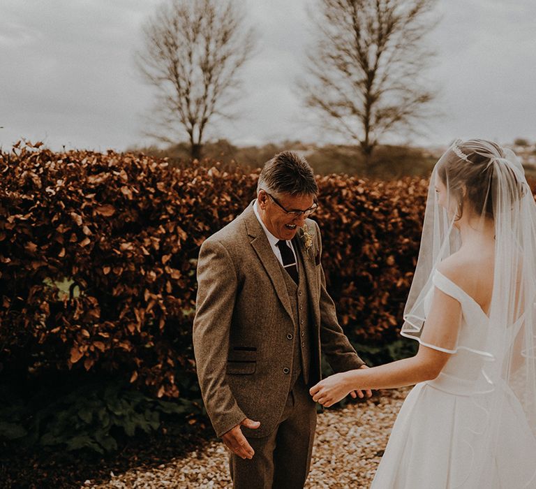 Emotional first look moment with the bride and the father of the bride as he sees her in a traditional bridal look 