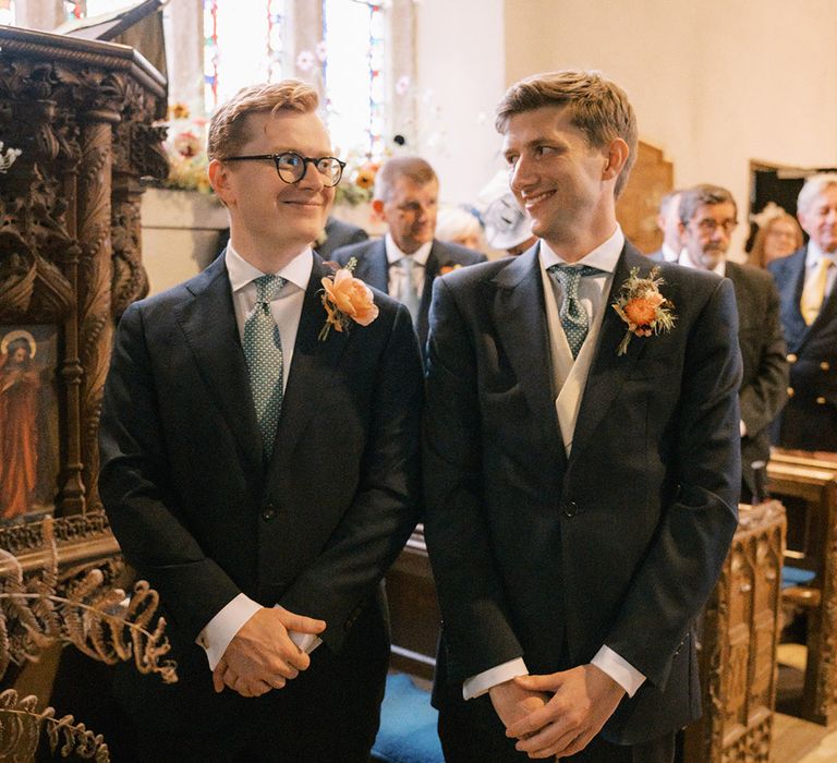 The groom stands with the best man just as the ceremony begins for Coombe Trenchard wedding 