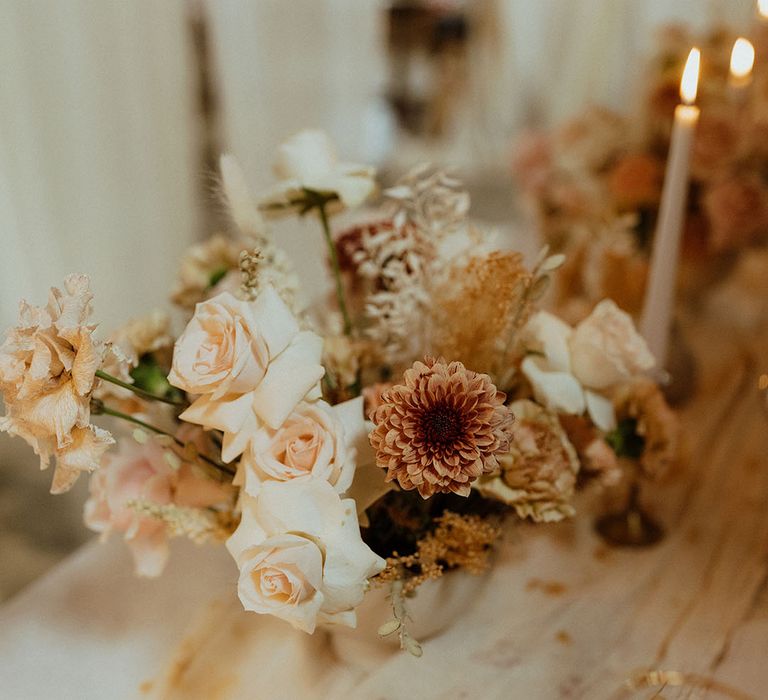 muted colour palette wedding flower arrangement, candles and bottle table decor 