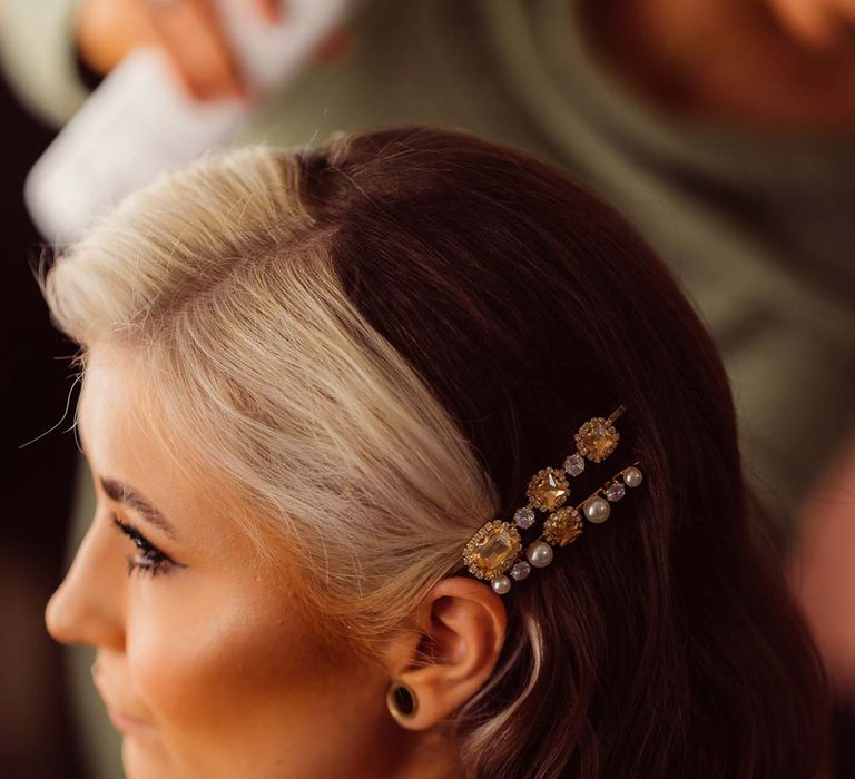 Bride with two-toned dyed hair wearing burnt orange getting ready robe and pearl and stone bridal hair slides 