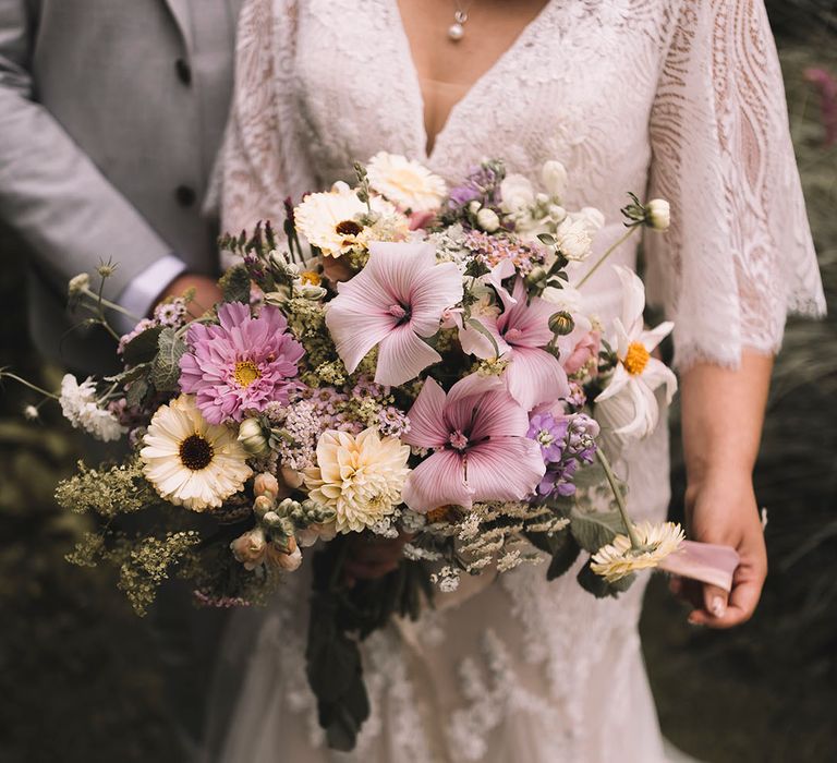 Pink and purple wedding bouquet with white florals including dahlias, rose mallow, gerbera and more 