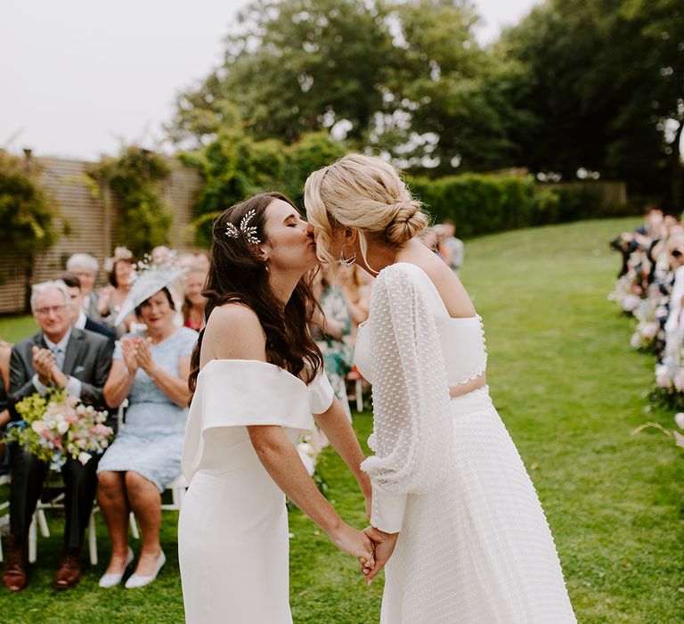 Two brides share their first kiss together at their outdoor ceremony in Dorset 