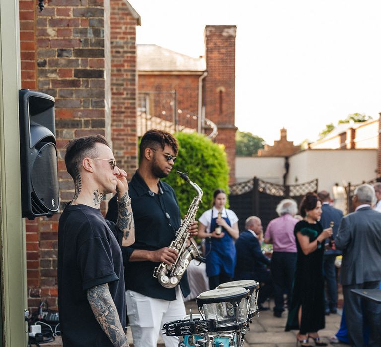 Weddin band plays at the wedding cocktail hour after the ceremony 