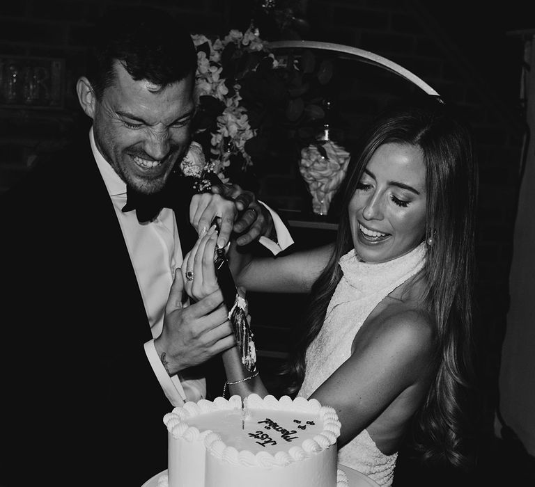 The bride and groom cut into their white heart shaped wedding cake 