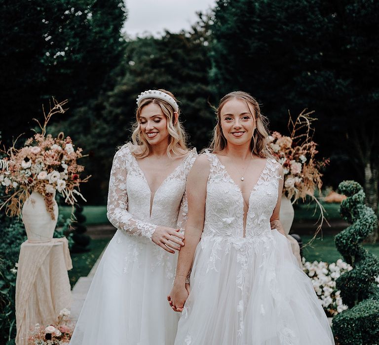 Two brides in lace wedding dresses with princess skirts at The Holford Estate garden wedding 