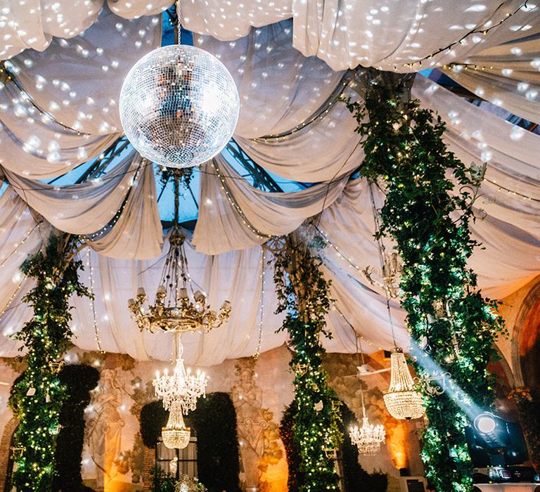 Disco ball, chandeliers and foliage decorating the castle wedding venue 