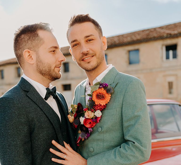 Groom in mint green suit with flower lapel and dark blue suit at elopement wedding 