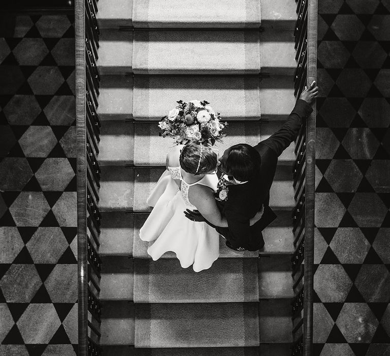 Overhead shot of the two brides walk up the stairs together 