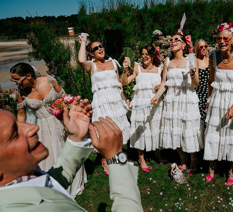 Bridal party wearing white ruffle bridesmaid dresses from Anne Louise Boutique 