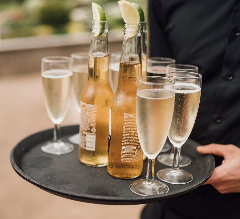 Champagne and beer on black serving tray 