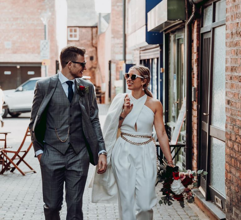 Stylish bride and groom walking down the street 