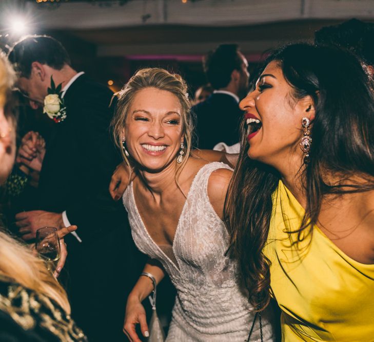 Bride in detachable sleeve wedding dress having a good time on the dance floor 