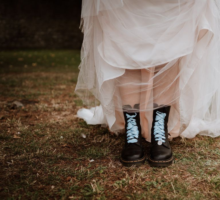 Bride in a tulle dress wearing wedding Dr Martens with blue laces 