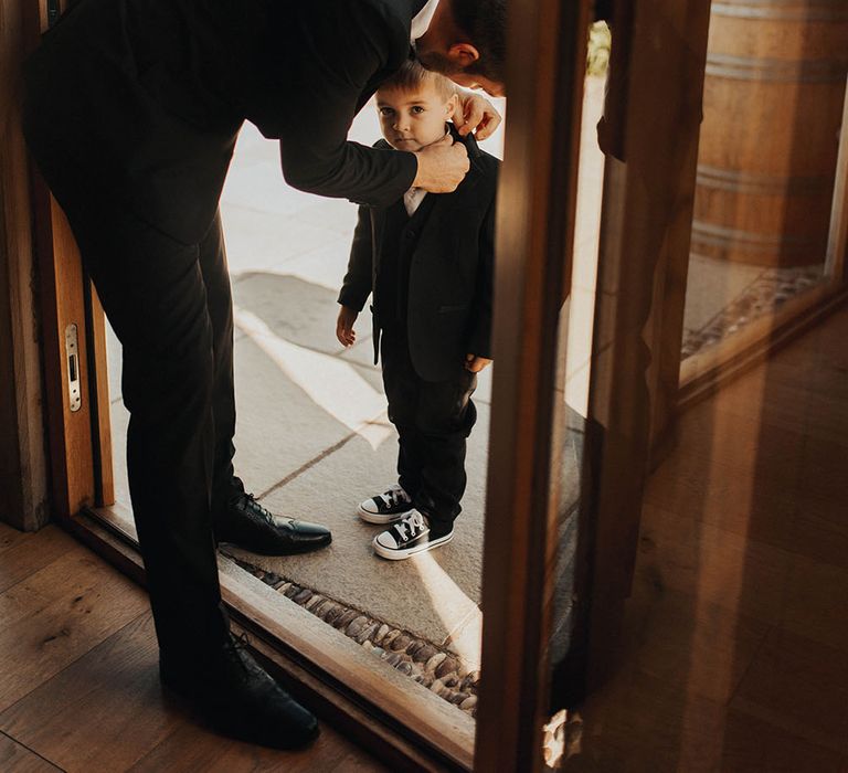 Groom gets his son ready for wedding ceremony