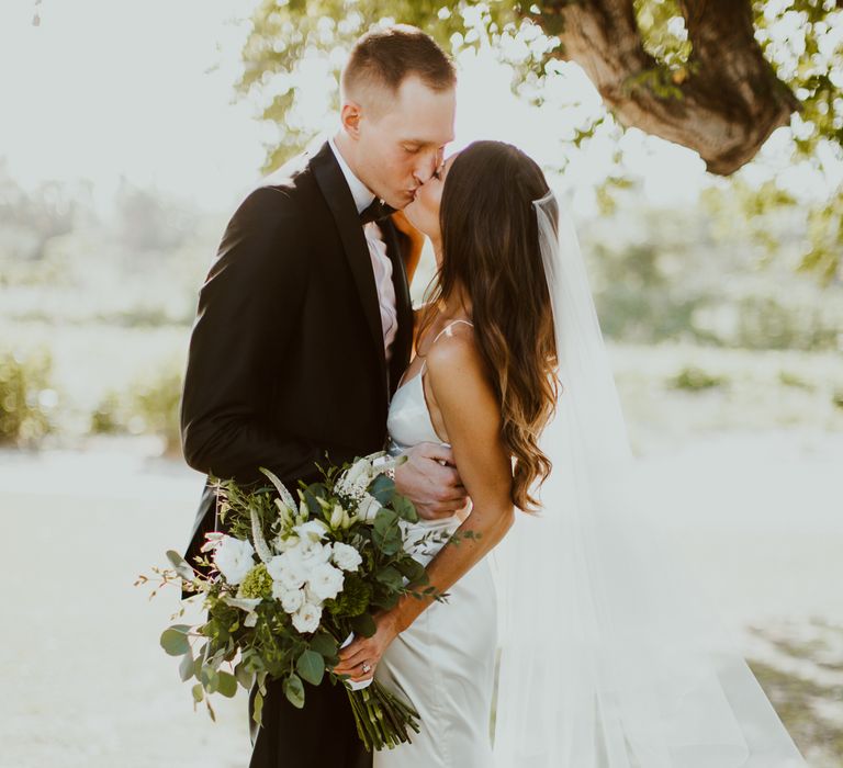 Bride and groom kiss after their wedding ceremony at Flora Farms