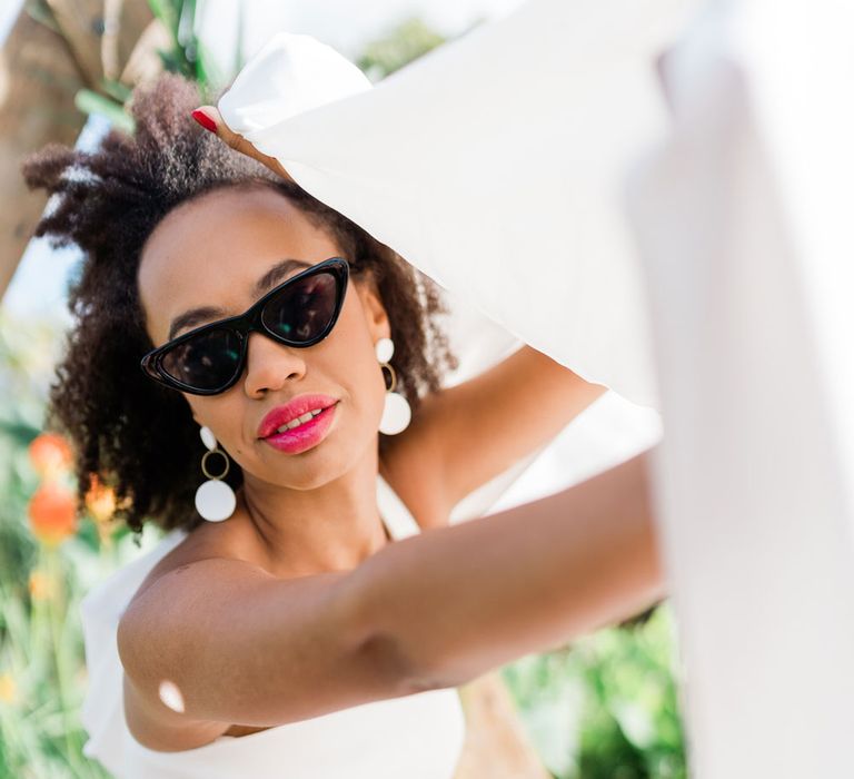 Bride in sunglasses, Maddox wedding dress and Muted Luxe handmade earrings