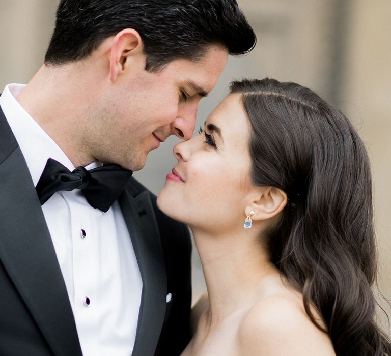 Black tie wedding with groom in a tuxedo and white bride with long brown wavy hair in a lace strapless wedding dress | Claire Moris Photography