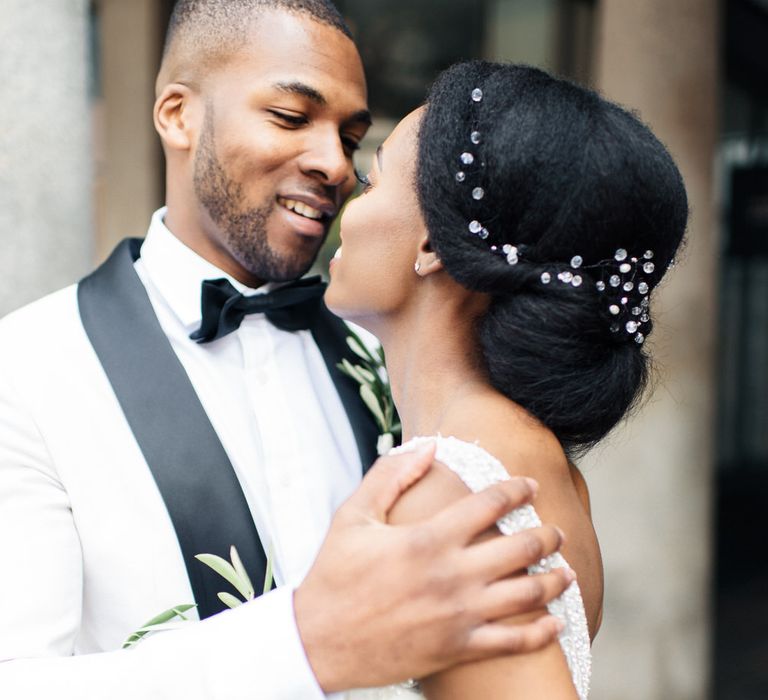 Black bride & groom kiss outside 