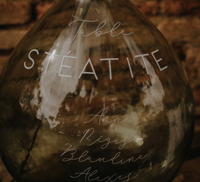 Seating chart written on an apothecary jar in white ink 