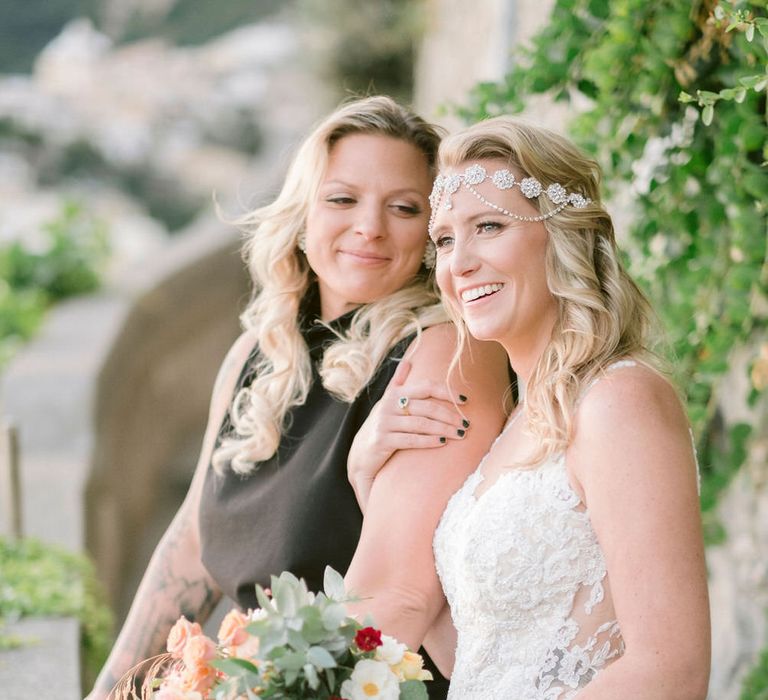 The brides smiling arm in arm at Hotel Marincanto, looking at the beautiful view